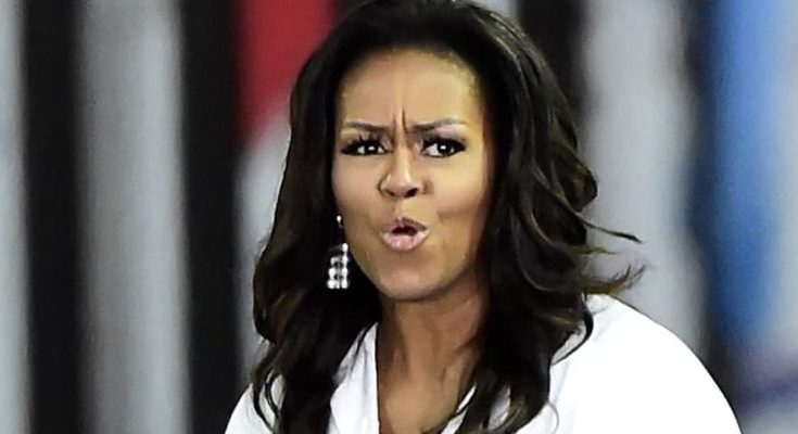 Michelle Obama with pursed lips and furrowed brow, wearing a white shirt and dangling