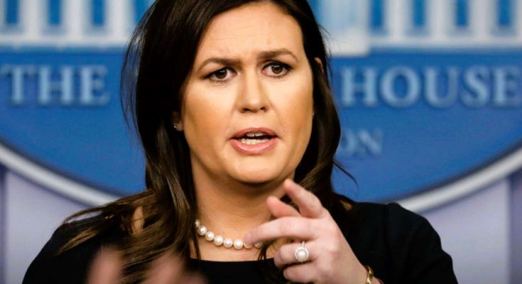 Sarah Huckabee Sanders speaking at a White House press briefing, wearing a black dress