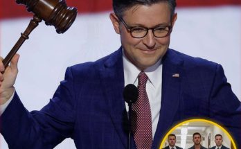 Man in blue suit holding a gavel at a podium with a red and white background, inset