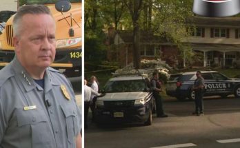 A police officer in uniform stands in front of a school bus, next to a photo of police