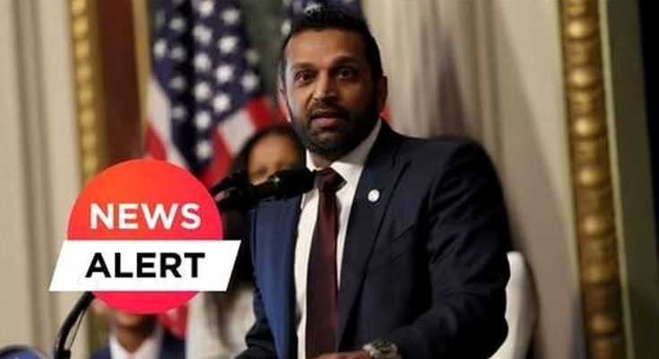 A man in a dark suit and tie speaking at a podium with microphones, with an American