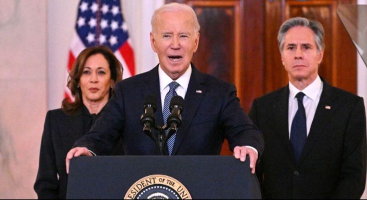 Joe Biden speaking at a podium with Kamala Harris and Antony Blinken standing behind