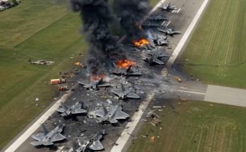 Aerial view of multiple fighter jets destroyed and burning on an airfield runway with