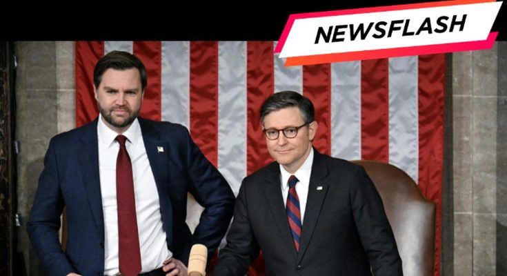 Two men in suits stand in front of an American flag backdrop, one holding a gavel, with