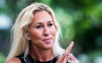 Marjorie Taylor Greene clapping outdoors with text overlay about election development