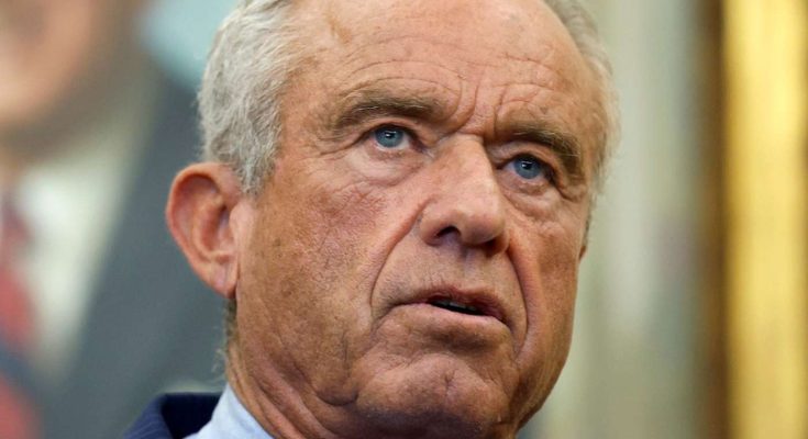 Close-up of Robert F. Kennedy Jr. with gray hair, wearing a pinstripe suit and light