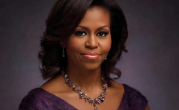 Portrait of Michelle Obama wearing a purple dress and ornate necklace with matching
