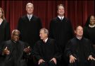 Group photo of nine Supreme Court justices in black robes against a red curtain