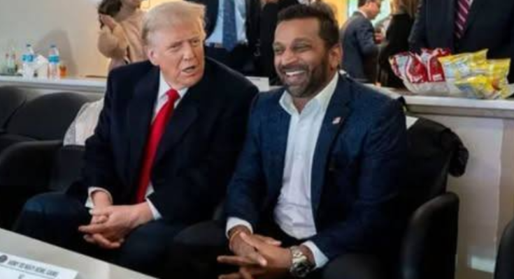 Kash Patel sitting with Donald Trump smiling