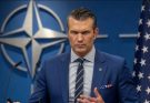 pete Hegseth speaks at NATO podium with breaking news headline about resignation