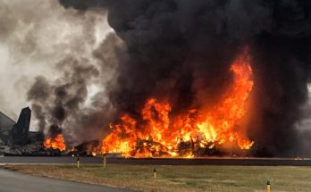 fiery plane crash on runway with thick black smoke