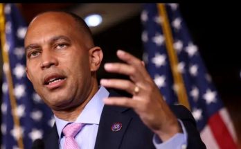 close-up of Congressman Hakeem Jeffries speaking passionately at a podium, wearing a dark
