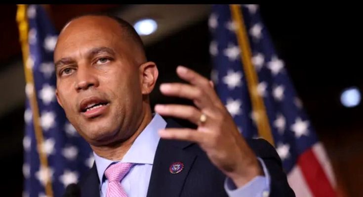 close-up of Congressman Hakeem Jeffries speaking passionately at a podium, wearing a dark