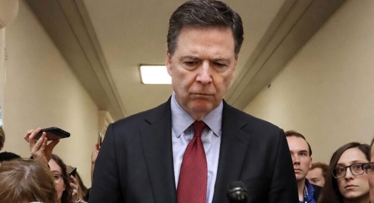 serious man in suit surrounded by reporters in a hallway