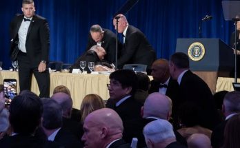 event audience watches emergency response on stage during speech