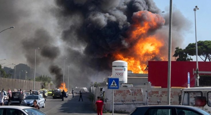 industrial fire sends black smoke skyward as emergency responders and 118 ambulance