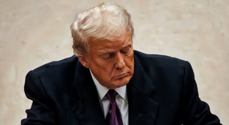 man in suit concentrating at desk with serious expression