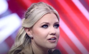 blonde woman speaking at event with red backdrop, 2028 political run focus