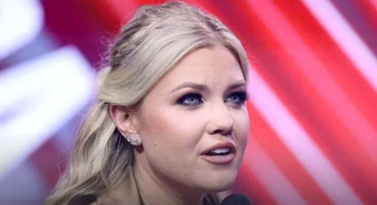 blonde woman speaking at event with red backdrop, 2028 political run focus