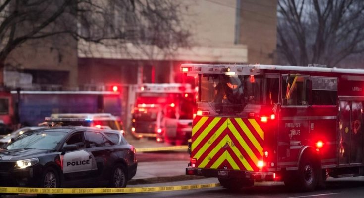 fire truck with chevron stripes and police SUV behind yellow crime scene tape at dusk