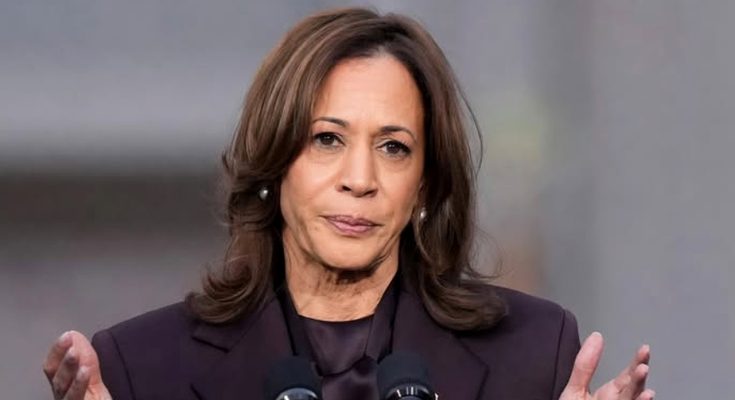 woman in purple suit speaking at outdoor event