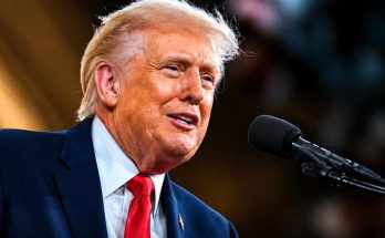 man speaking into microphone at a formal event