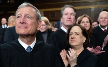 chief Justice Roberts and Supreme Court justices applauding in black robes with headline