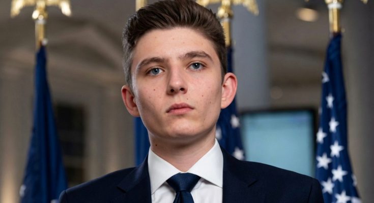 young man in suit with flags in background, serious expression, political setting