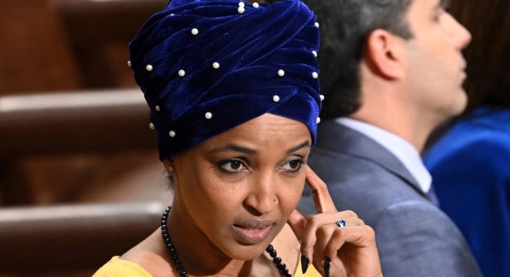 woman in blue turban with pearls, thoughtful expression, seated indoors
