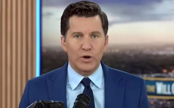 news anchor in blue suit delivering headline on camera