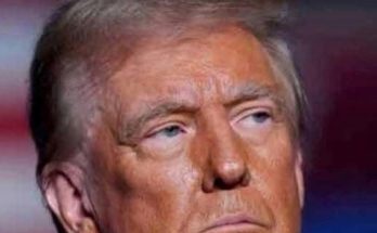 close-up portrait of Donald Trump with serious expression against blurred red and blue