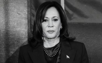 woman in formal attire with serious expression, indoors setting