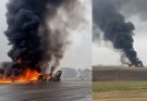 airplane engulfed in flames on runway with thick smoke rising