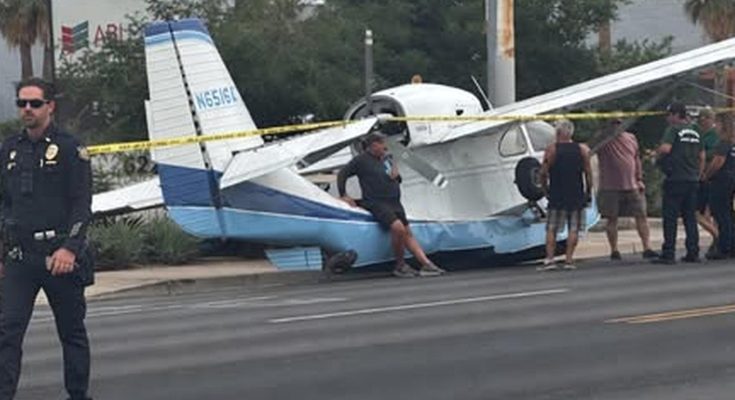 small plane crash lands on street with police and onlookers nearby