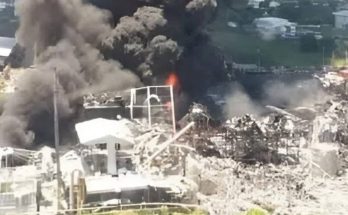 massive smoke cloud from industrial fire near buildings