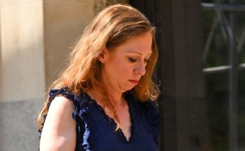 woman in blue top walking outdoors on a sunny day