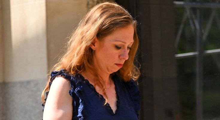 woman in blue top walking outdoors on a sunny day