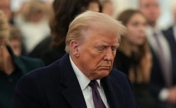 serious man in suit amid crowd at formal event