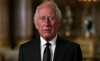 elderly man in black suit in elegant room, solemn expression, royalty theme