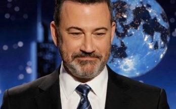 smiling man in suit with moon backdrop on TV set