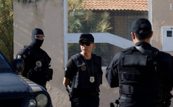 police officers in tactical gear outside residential building