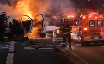 firefighters respond to a blazing car on highway at night