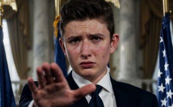young man in suit extends hand, looking emotional in official setting