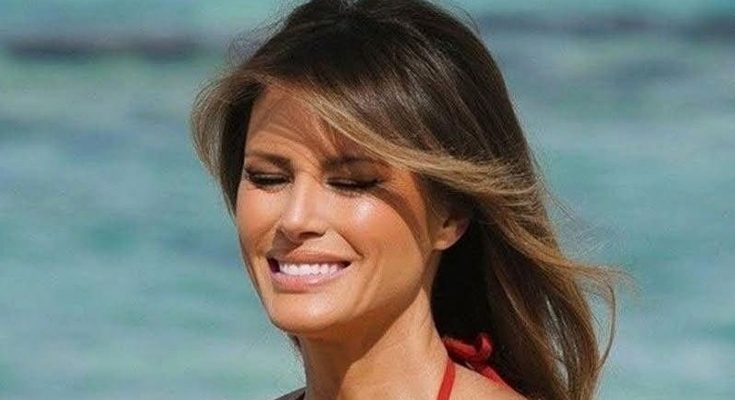 woman in red bikini smiling at sunny beach, eyes closed