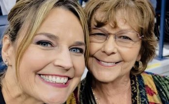 two women smiling broadly at a lively indoor event