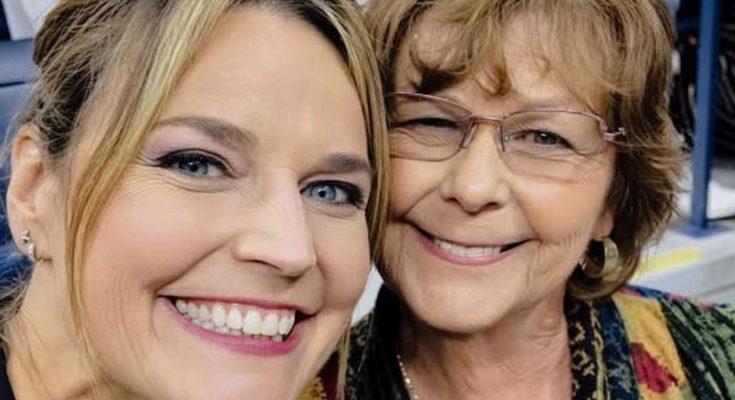 two women smiling broadly at a lively indoor event