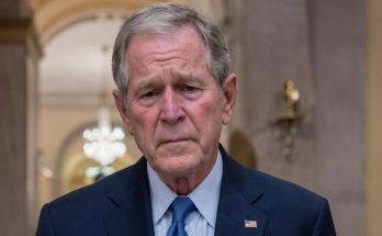 serious man in suit inside elegant hall with chandeliers