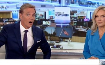 news anchors discussing current events in a busy newsroom