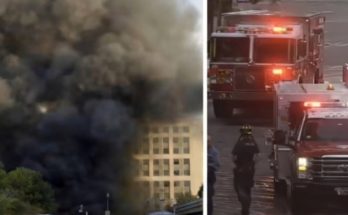smoke billows from building as emergency vehicles respond to fire