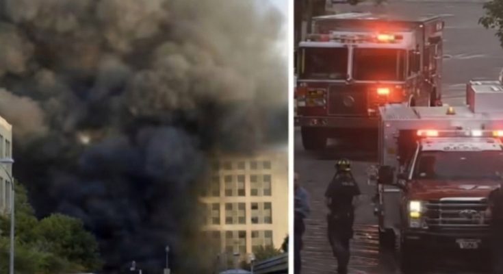 smoke billows from building as emergency vehicles respond to fire